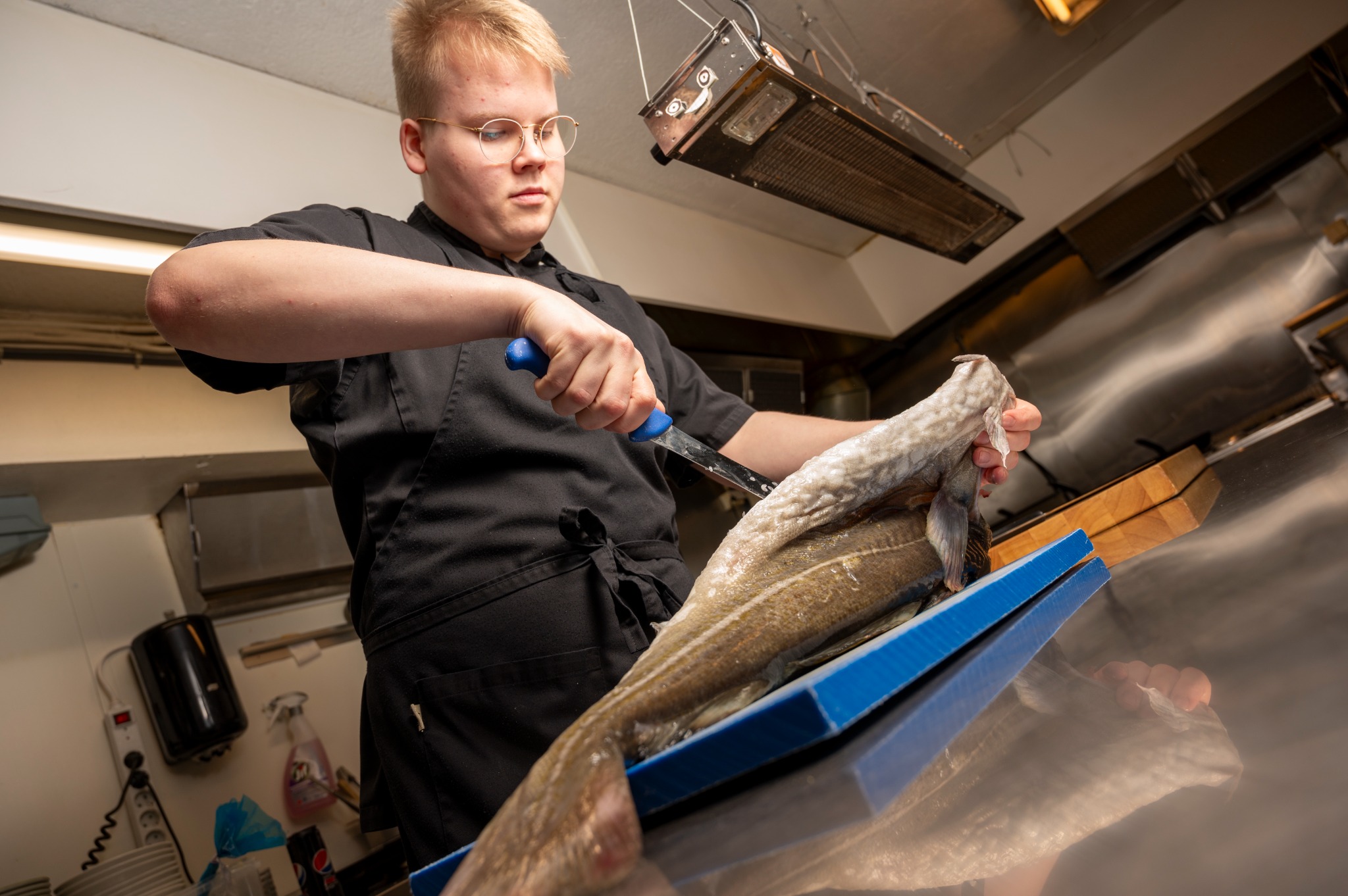 En kokk hos Fiskekroken klargjør fersk fisk
